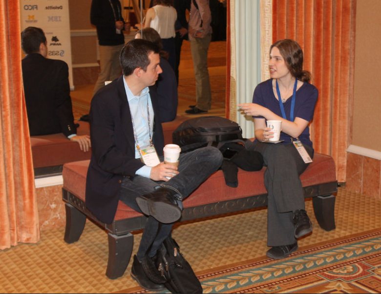 Two Members discussing something on a bench, out of the way at the 2017 Analytics Conference